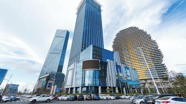 Uno skyline urbano moderno con grattacieli, tra cui una struttura curva particolare e un alto grattacielo dal design originale.