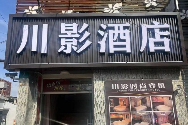 A hotel sign with Chinese characters and a smaller sign below it. - Chuanying Fashion Hotel (Shanghai)