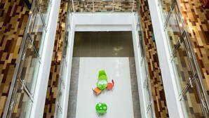 A high-angle view of a lobby with a tiled floor, a glass railing, and a seating area with chairs and a table. - Motel Lijiang Xueshan Road (Lijiang)