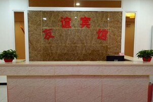 A reception desk with a marble wall and red Chinese characters.