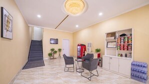 A modern interior with a staircase, seating area, and a vending machine.