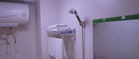 A bathroom with a towel rack, a shower, and a wall-mounted heater.