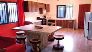 Une cuisine dotée d’un îlot central, de tabourets, d’un réfrigérateur et d’un distributeur d’eau.