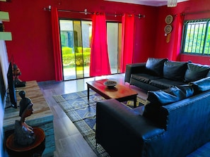 A living room with a sofa, a coffee table, and a television. - Cozy Private Oasis in Lusaka w/Pool, AC, Starlink High-speed Wi-Fi +Pet-Friendly (Lusaka)