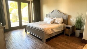 A spacious bedroom with a large bed, a ceiling fan, and a view through the window. - Luxury Home on Secluded Ranch, near beaches and hiking (San Diego)