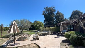 A patio area with outdoor furniture, a hammock, and a pergola with string lights. - Luxury Home on Secluded Ranch, near beaches and hiking (San Diego)