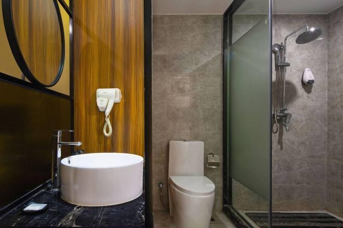 Bathroom features a large round sink, toilet, and glass-enclosed shower.