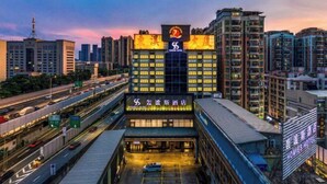 Un hotel con una segnaletica ben visibile, diversi piani e un'area di parcheggio.