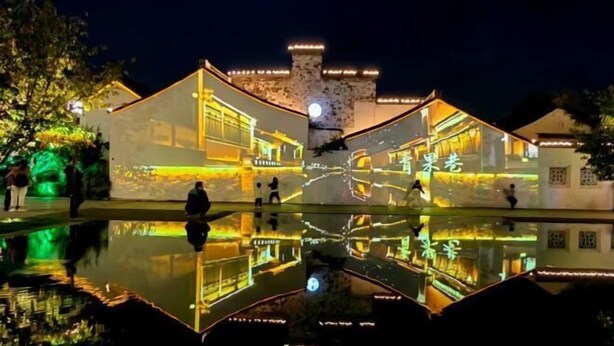 A traditional building with a moat, illuminated by warm lights, reflecting in the water. - Jiahao Hotel (Changzhou)