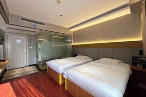 Habitación de hotel con dos camas, un separador de vidrio, suelo de madera y un diseño moderno.