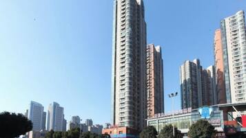 A high-rise building with multiple floors, surrounded by other tall buildings, under a clear sky.
