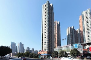 A high-rise building with multiple floors, surrounded by other tall buildings, under a clear sky. - Jiahao Hotel (Changzhou)