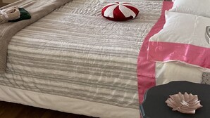 Un dormitorio con cama, mesita de noche y mesilla.