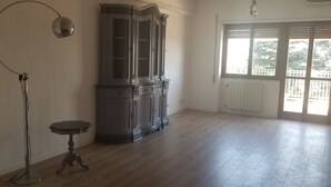 Una habitación amplia con un armario grande, una mesita y una lámpara de pie.