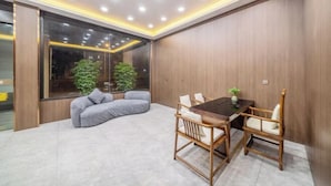 Una habitación moderna con un sofá curvo, una mesa de comedor de madera y sillas.