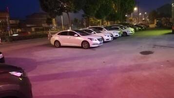 Un estacionamiento con varios coches aparcados en fila.