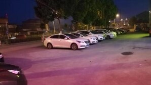 Una hilera de coches estacionados en un aparcamiento por la noche.