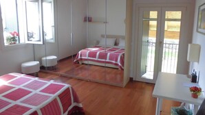 Une chambre à coucher avec un lit, une table de chevet, un miroir et une fenêtre.