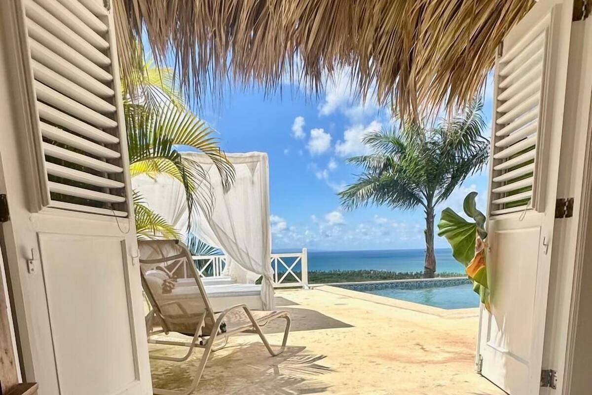 A bedroom with a view of a beach and ocean.