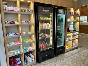 Una tienda de conveniencia con secciones refrigeradas, estantes llenos de aperitivos, bebidas y artículos de aseo.