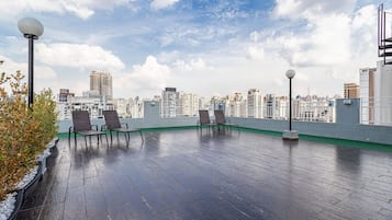 A rooftop terrace with seating and a city view.