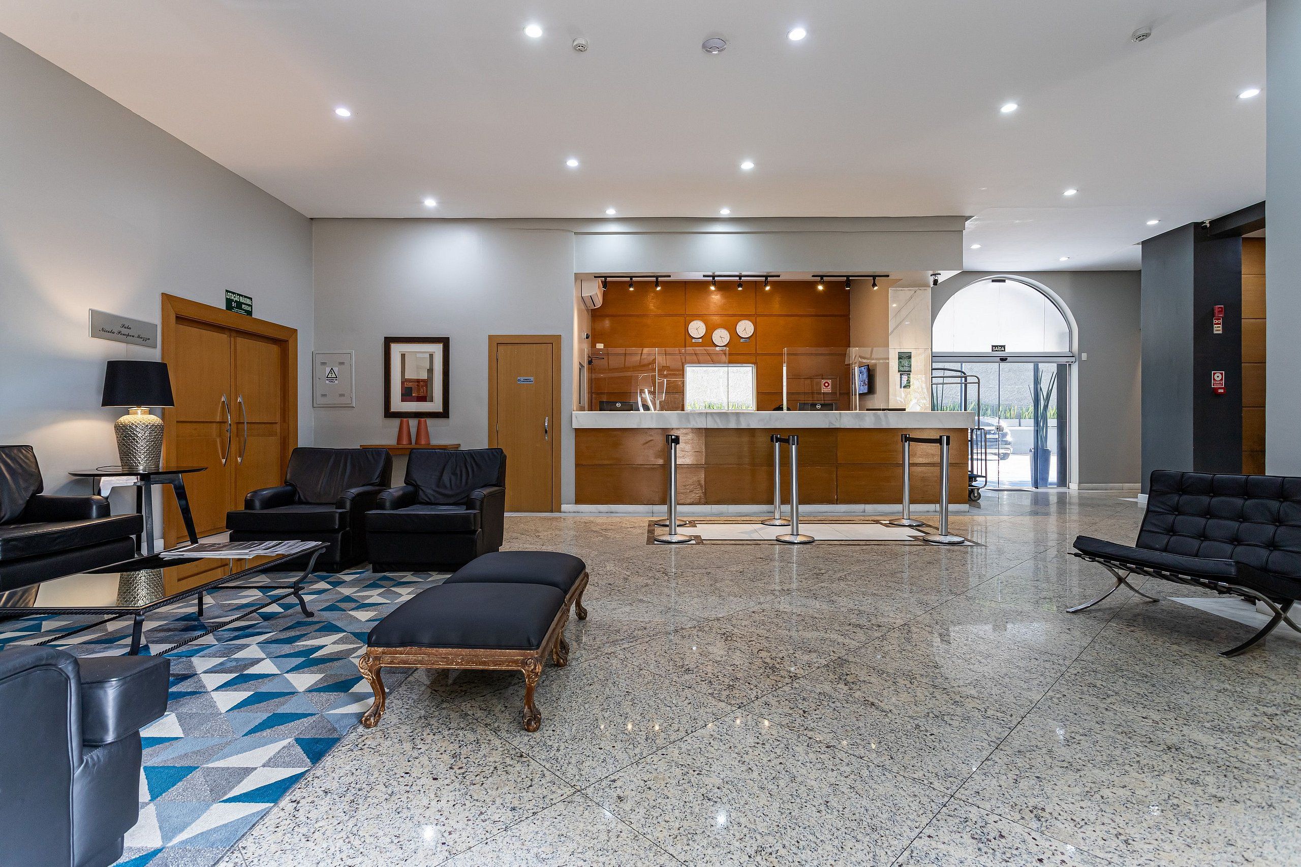 A lobby with seating, a reception desk, and a view of the outside.