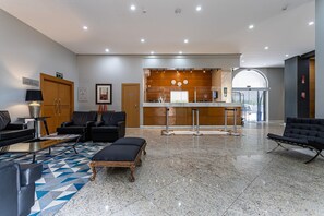 A lobby with seating, a reception desk, and a view of the outside. - Perdizes Residence Flat Condomínio  (São Paulo)