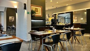 A restaurant interior with tables, chairs, a counter, and a large window. - Perdizes Residence Flat Condomínio  (São Paulo)