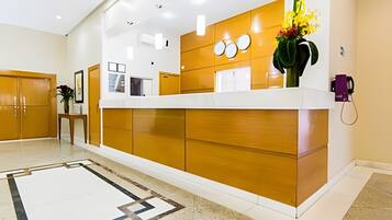 A reception area with a wooden reception desk, a white floor, and a reception counter.