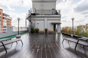 A rooftop terrace with a view of the city, a staircase, and a bench area. - Perdizes Residence Flat CondomĂnio (SĂŁo Paulo)