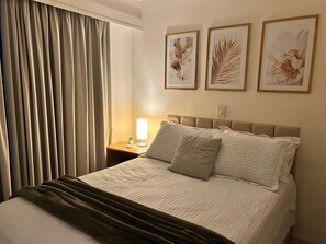 A hotel room with a bed, a nightstand with a lamp, and three framed botanical prints on the wall. - Perdizes Residence Flat CondomÃnio (São Paulo)