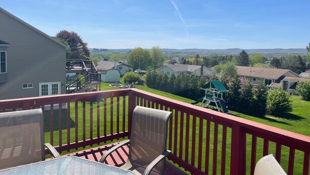 Un balcon offrant une vue dégagée sur un quartier résidentiel, avec ses maisons et sa végétation.