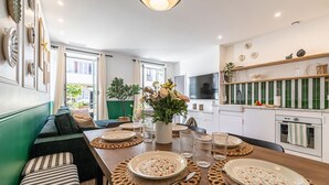 Een moderne keuken met een eethoek, met een houten tafel voor vier personen, een bank en uitzicht op de stad.