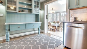 A kitchen with teal cabinetry, a stainless steel dishwasher, and a patterned rug. - 4 Mi to Inkwell Beach: Home in Oak Bluffs! (Vineyard Haven)