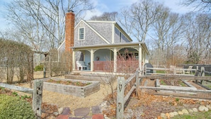 A two-story house with a porch and a fenced garden area. - 4 Mi to Inkwell Beach: Home in Oak Bluffs! (Vineyard Haven)