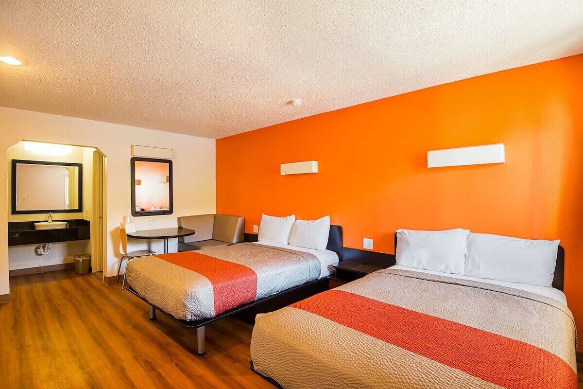Una habitación de hotel con dos camas, un escritorio y una silla.