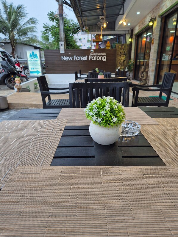 Ein Sitzbereich im Freien mit Tisch, Stühlen und einem Blumentopf.