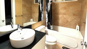 Ein modernes Badezimmer mit zwei Waschbecken, einer Toilette und einer Badewanne.