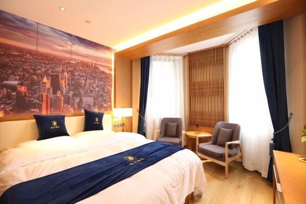 A hotel room with a large bed, two armchairs, a small table, and a cityscape mural on the wall. - Super 8 Hotel (Beijing Qianmen Tiantan Park) (Beijing)