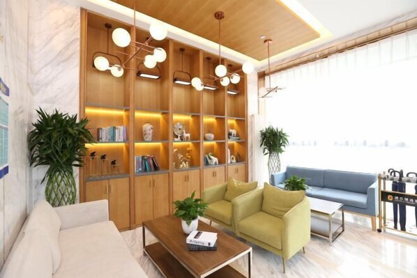 A modern living room with a wooden bookshelf, two sofas, a coffee table, and a large window. - Super 8 Hotel (Beijing Qianmen Tiantan Park) (Beijing)