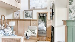 A spacious living area with a high ceiling, a chandelier, a sofa, a coffee table, and a bed with a view. - Lux 5BR w/ Theater, Fire-pit, Private Office + Guest Cottage, Close to Downtown (Highlands)