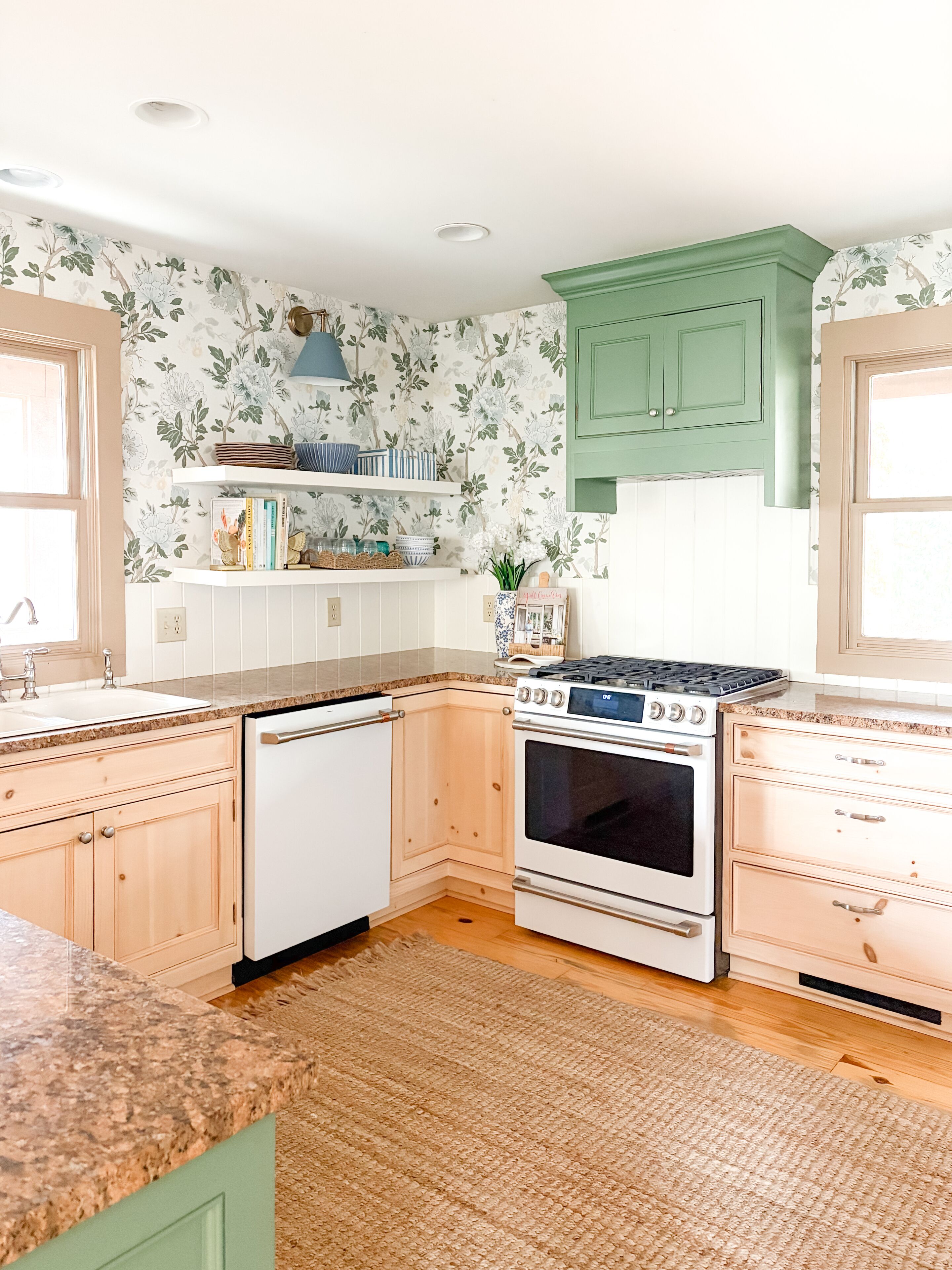 A kitchen with white cabinets, a stove, and a dishwasher.