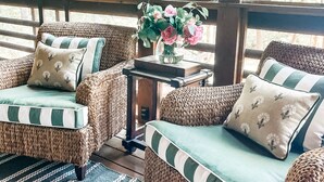 A cozy seating area with wicker furniture and a vase of flowers. - Lux 5BR w/ Theater, Fire-pit, Private Office + Guest Cottage, Close to Downtown (Highlands)