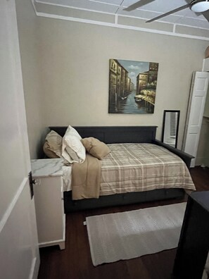A bedroom with a bed, a painting of a canal, a heater, and a small cabinet. - Charmer 2bed house fenced in Broken Arrow. Rose District 1 block off Main pet ok (Broken Arrow)