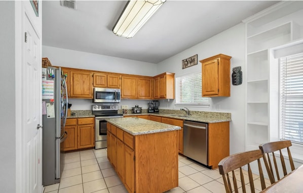 Kitchen features a microwave, oven, and dishwasher, along with a refrigerator and sink.