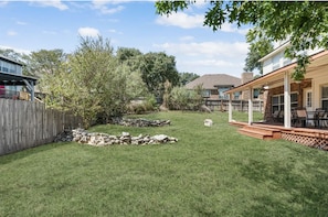 Enjoy a serene outdoor living space with a well-maintained lawn, patio, and pergola.
