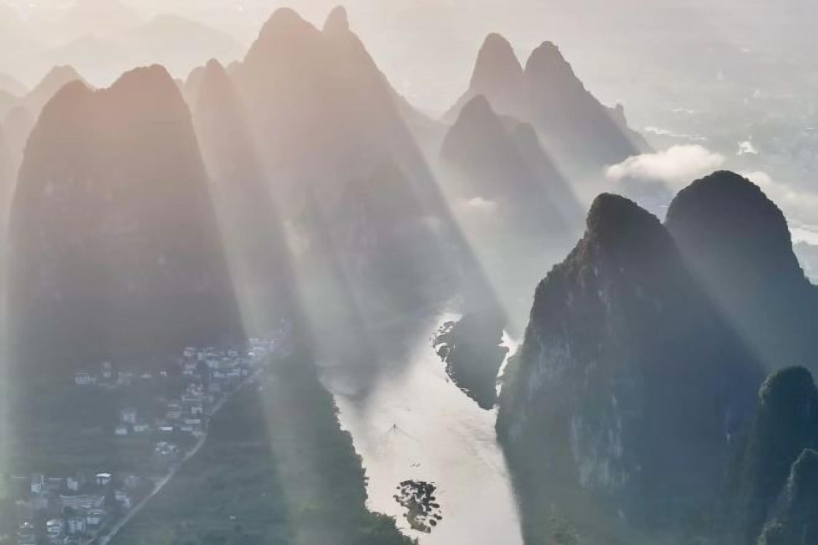 A mountainous landscape with a river and a town below.