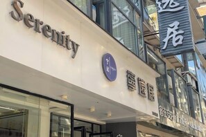 A hotel named Serenity with a modern facade, a prominent sign, and a visible entrance. - Serinity Hotel (Yangshuo West Street Lijiang Branch) (Yangshuo)