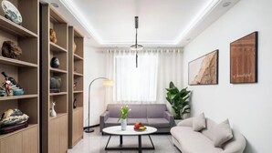 A modern living room with a sofa, a coffee table, and a bookshelf.