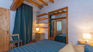 A bedroom with a bed, a chair, a desk, a lamp, and a mirror. - Principe Marmolada 817/A (Rocca Pietore)